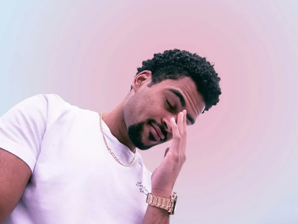 A person holding their face in their hands, looking overwhelmed