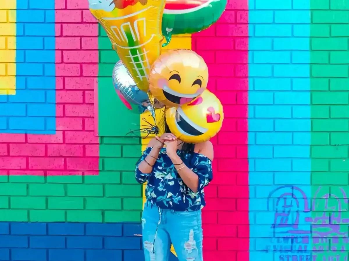 A person behind a smiling balloon