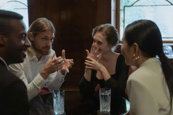Several people talking around a table in a calm, supportive conversation