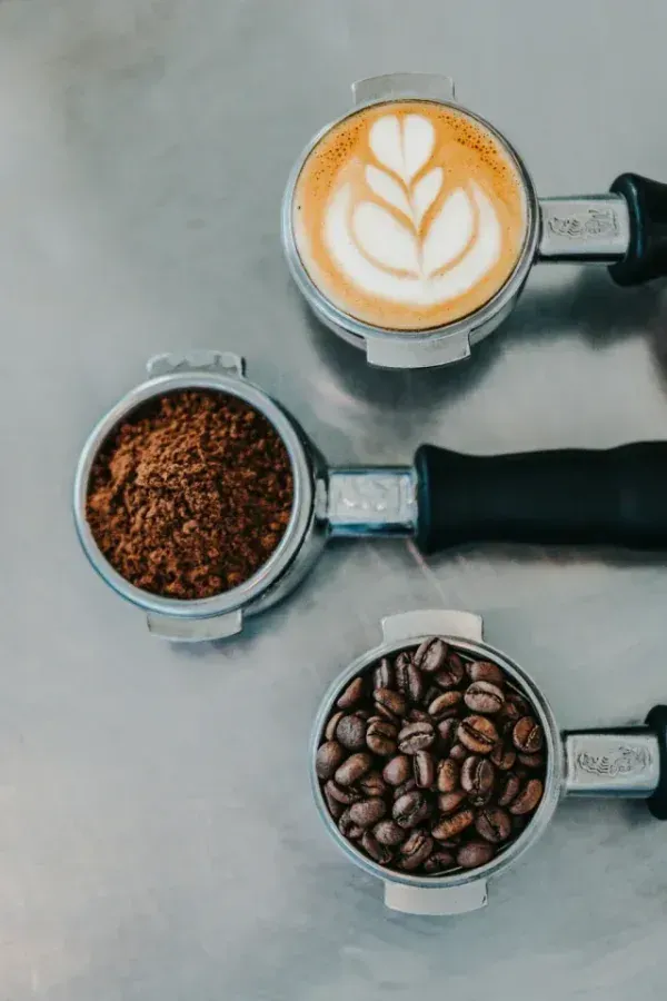 Coffee being prepared from beans to ground coffee to a brewed cup