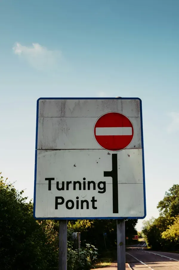 A road sign reading 'Turning Point' beneath a no-entry symbol