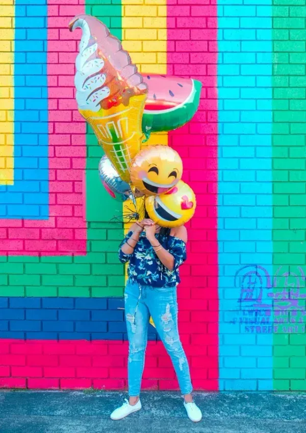 A person behind a smiling balloon